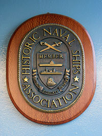 Памятная табличка о вступлении крейсера 1-го ранга  "Аврора" во всемирную ассоциацию исторических кораблей.  Вручена 26 мая 2004 года.